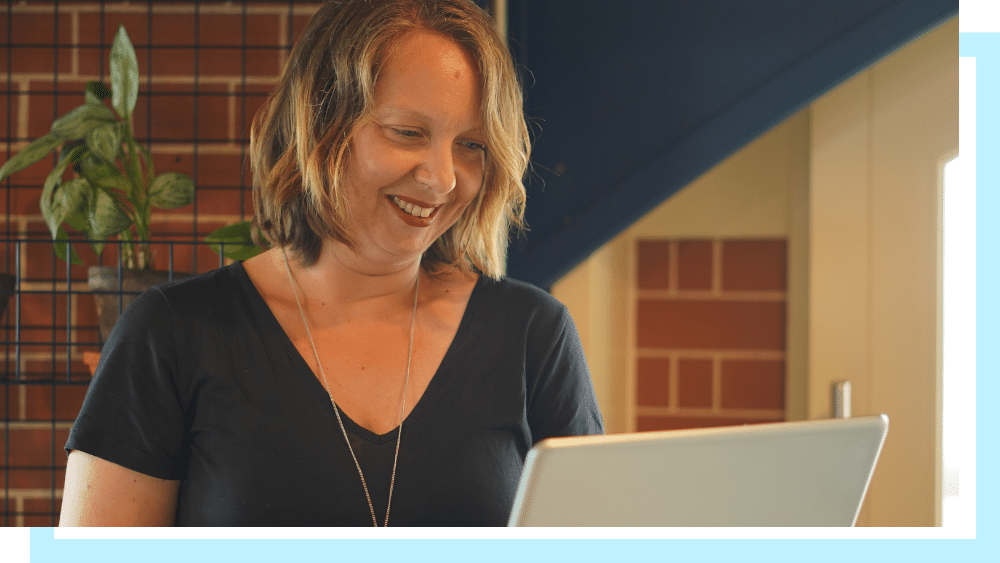 Allegra Chapman, a middleaged white woman in a black top, working on a laptop