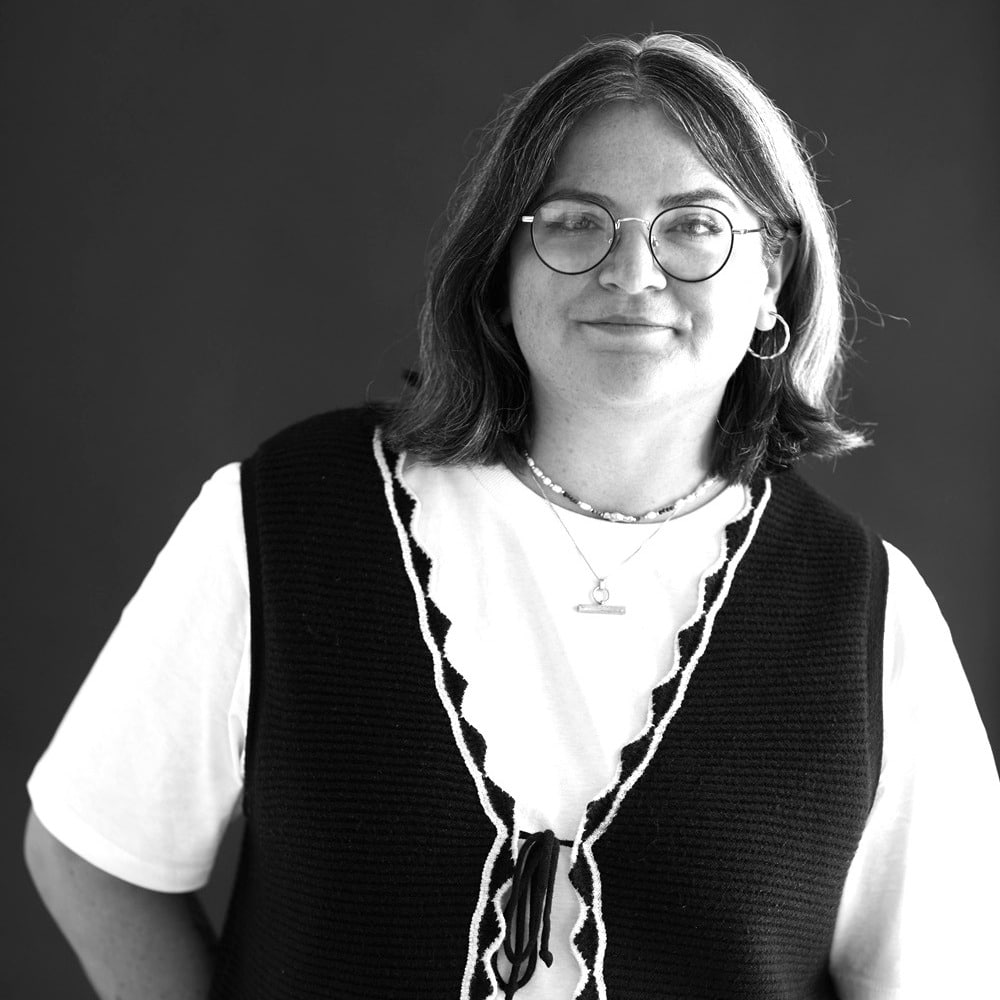 Jess Molloy, a black and white image of a young white woman with dark shoulder length hair and glasses