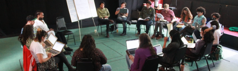 A mixed group of playwrights working on material in a circle.